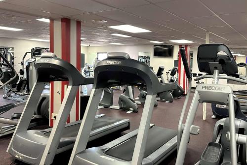 a gym with rows of treadmills and machines at Ramada by Wyndham Waupaca in Waupaca