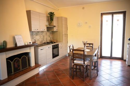 une cuisine avec une table à manger et une cheminée dans l'établissement Natuscia Country Villa - Private Jacuzzi - Garden, à Ronciglione