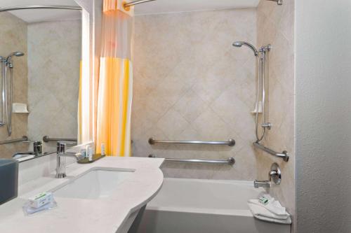 a bathroom with a tub and a sink and a shower at La Quinta by Wyndham Ft. Pierce in Fort Pierce