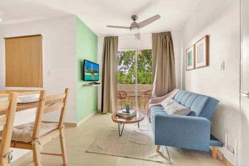 a living room with a blue couch and a table at OASIS Punta Cana Apartment in Punta Cana