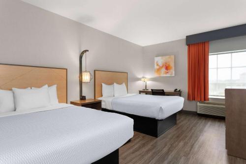 a hotel room with two beds and a window at La Quinta by Wyndham Ft. Pierce in Fort Pierce