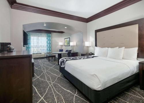 a hotel room with a large bed and a desk at La Quinta by Wyndham Little Rock - Bryant in Bryant