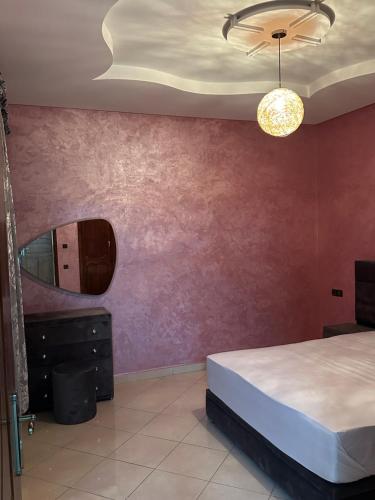 - une chambre avec un lit et un miroir dans l'établissement Luxury Modern Apartment, à Béni Mellal