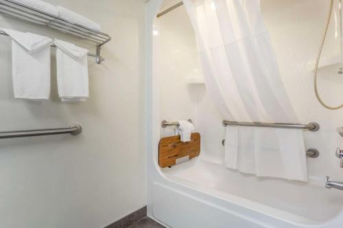 a bathroom with a tub and a shower with towels at Sleep Inn Sea Tac Airport in SeaTac