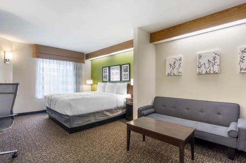 um quarto de hotel com uma cama e um sofá em Sleep Inn Sea Tac Airport em SeaTac