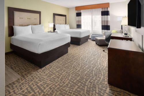 a hotel room with two beds and a desk at Wyndham Garden Buffalo Downtown in Buffalo