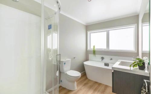 uma casa de banho com um WC, uma banheira e um lavatório. em Sunshine Haven - New 3-Bedroom 4-Beds in Paraparaumu em Paraparaumu