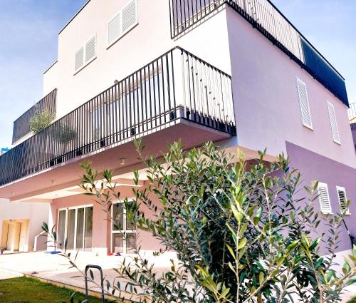 a white building with a balcony on it at Arte Oliva in Grebaštica