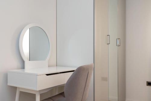 a white dressing table with a mirror and a chair at Apartman Palma and Luxury Penthouse for a family with swiming pool,parking,terrace,panoramic view at the sea,Podstrana in Podstrana
