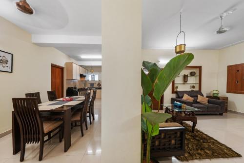 een eetkamer en een woonkamer met een tafel en stoelen bij Willow - 2BHK in Bangalore