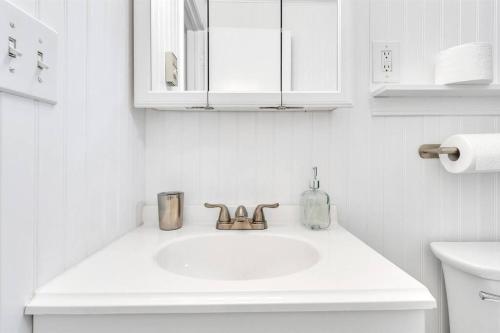 a white bathroom with a sink and a mirror at Central Chic Crib in Manchester