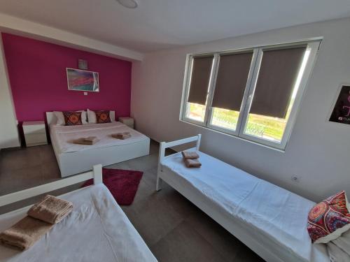 a bedroom with two beds and a window at Flamingo Resort in Belgrade