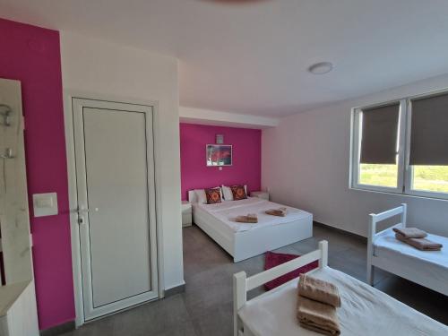 a bedroom with pink walls and a bed and a window at Flamingo Resort in Belgrade