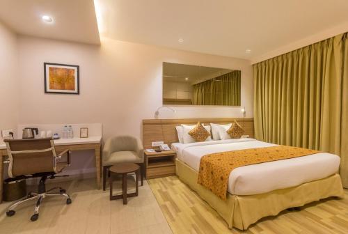 Habitación de hotel con cama y escritorio en Hotel Palacio en Guwahati