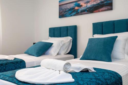 a room with three beds with towels on them at Apartman Palma and Luxury Penthouse for a family with swiming pool,parking,terrace,panoramic view at the sea,Podstrana in Podstrana