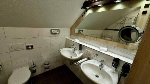a bathroom with two sinks and a mirror and a toilet at Kaiserhof in Willich