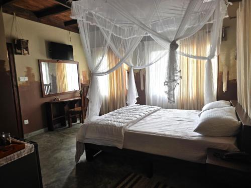 a bedroom with a white canopy bed with a mirror at Dorala Villa-Your home away home in Kuruwita