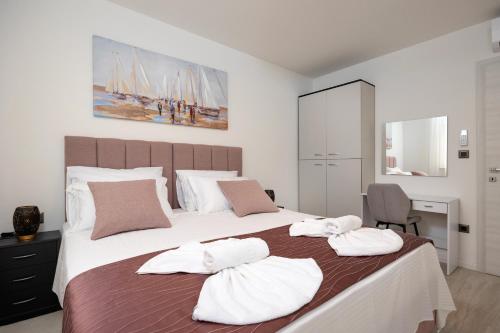 a bedroom with a large bed with towels on it at Apartman Palma and Luxury Penthouse for a family with swiming pool,parking,terrace,panoramic view at the sea,Podstrana in Podstrana