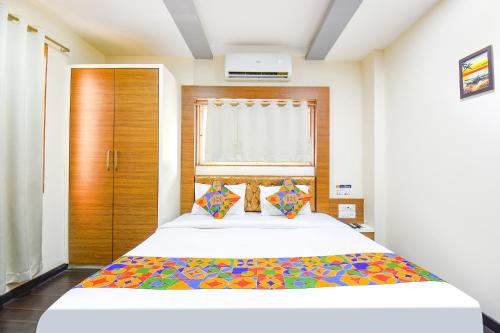 Un dormitorio con una cama grande y una ventana en FabHotel Royal Empire, en Chinchwad