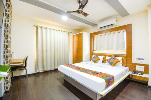 Un dormitorio con una gran cama blanca y una ventana en FabHotel Royal Empire, en Chinchwad