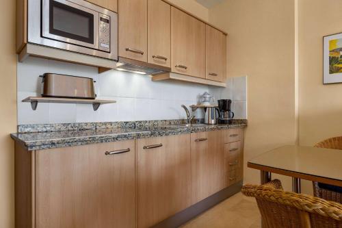 eine Küche mit einer Spüle und einer Mikrowelle in der Unterkunft Wyndham Grand Costa del Sol in Mijas Costa