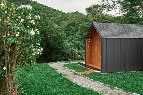 a small brown shed sitting in the grass at Baan Rai Santisuk in Ban Sok Dua