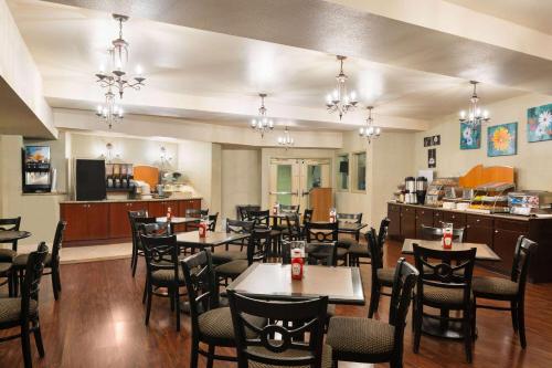 a dining room with tables and chairs in a restaurant at Hotel Marguerite South Anaheim - Garden Grove, Trademark Collection by Wyndham in Anaheim