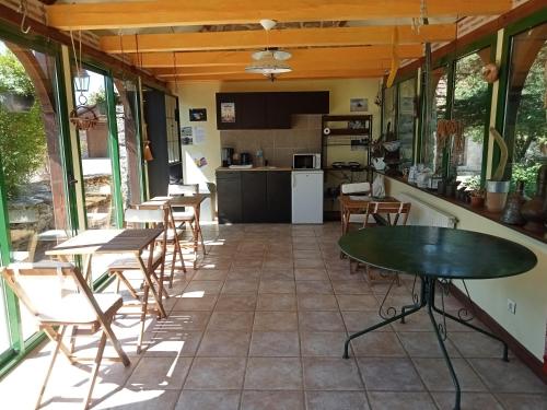 a patio with tables and chairs and a kitchen at Chambres d'hôte Mas de Bouzou in Grèzes