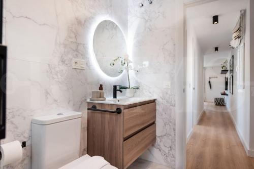 a bathroom with a toilet and a sink and a mirror at Apartment with Cathedral view & terrace by REMS in Málaga