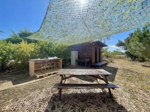 - une table de pique-nique avec un grand morceau de verre au-dessus dans l'établissement Glamping on Organic Yoga Farm with Natural Swimming Pool near Beach, à Moncarapacho