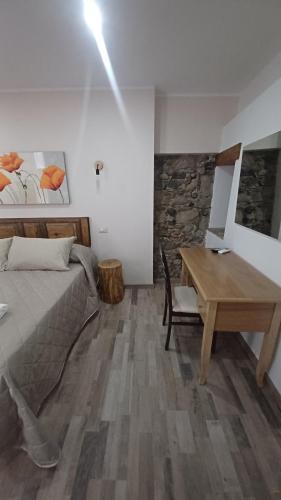 1 dormitorio con cama y escritorio de madera en B&B Le Vie del Borgo en Castiglione di Sicilia