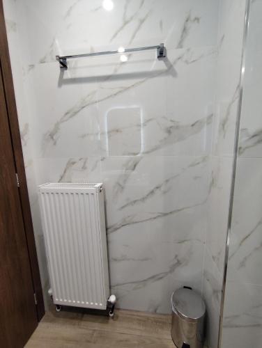 a white marble wall in a bathroom with a radiator at Ζέον Ύδωρ in Órma
