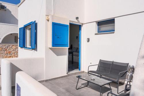 a patio with a chair and a table on a building at Aegean Blue Santorini Perissa ii in Perissa