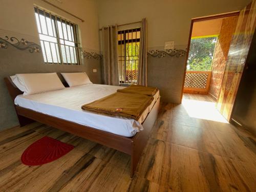 sypialnia z dużym łóżkiem i drewnianą podłogą w obiekcie Dakshinamurthi Beach Stay w mieście Gokarna