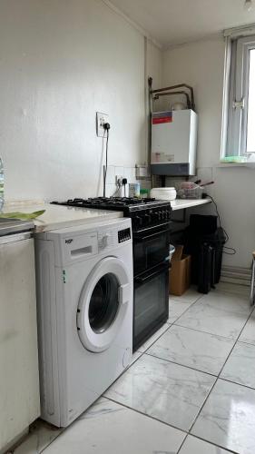 a kitchen with a washing machine and a stove at Sheringham Tower in Southall