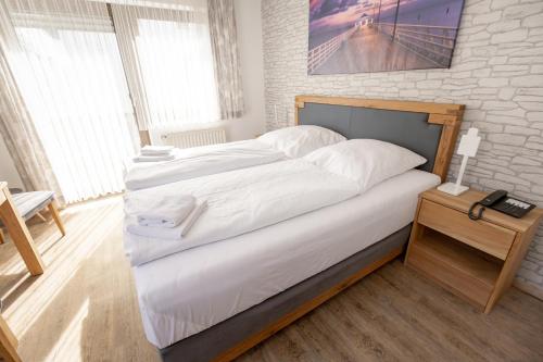 ein Schlafzimmer mit einem großen Bett mit weißer Bettwäsche in der Unterkunft Hotel-Restaurant Zum Schwalbennest in Alsfeld