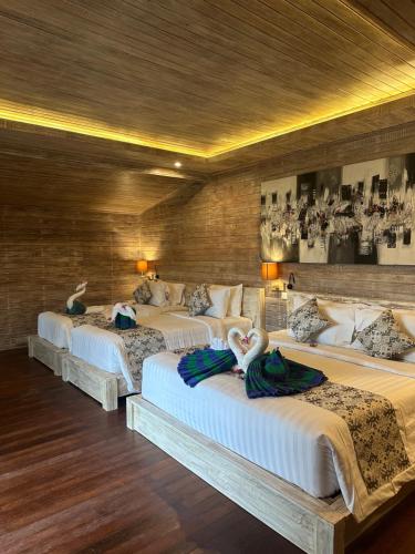 a group of four beds in a room at The Niti Hut's Lembongan in Nusa Lembongan