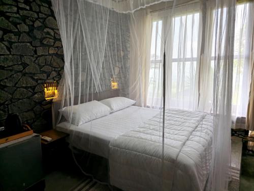 a bedroom with a large bed with a window at Dorala Villa - on the way to Ella, Udawalawa or Mirissa in Kuruwita