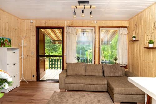 - un salon avec un canapé et une grande fenêtre dans l'établissement Lovely summerhouse 40km from berlin!, à Biesenthal