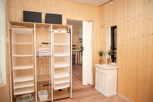 une chambre avec des murs en bois et une chambre avec des étagères dans l'établissement Lovely summerhouse 40km from berlin!, à Biesenthal