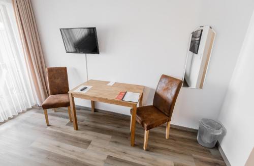 einen Tisch und zwei Stühle in einem Zimmer in der Unterkunft Hotel-Restaurant Zum Schwalbennest in Alsfeld