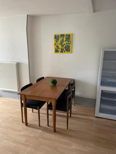 a wooden table and chairs in a room at Bel appartement 2 chambres n11 in Moulins