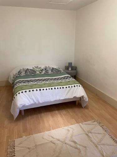 a white bedroom with a bed with a rug at Bel appartement 2 chambres n11 in Moulins