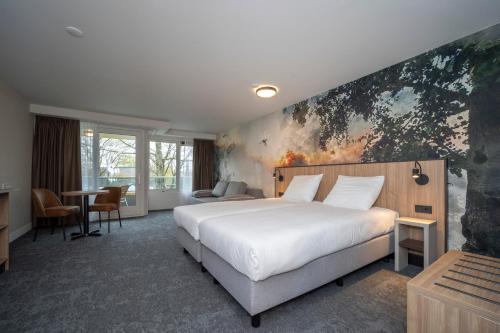 a bedroom with a white bed and a painting on the wall at Fletcher Hotel-Restaurant Langewold in Roden