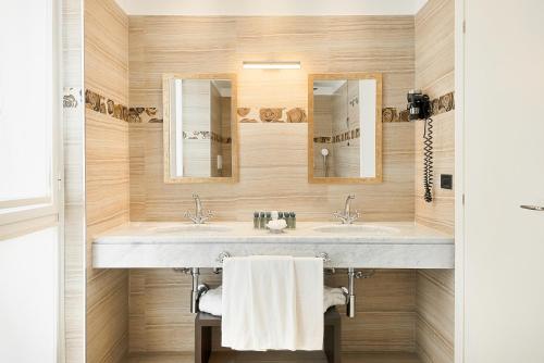 a bathroom with two sinks and two mirrors at Hotel Excelsior in Marina di Massa