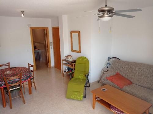 a living room with a couch and a table and chairs at Delfines III Solo Familias Serviplaya in Playa de Xeraco