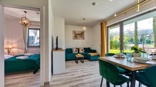 a bedroom and living room with a table and a bed at Apartamenty z basenem i saunami STONE HILL RESORT II VIP Centrum by Royal Aparts in Szklarska Poręba