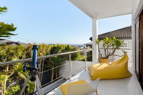 a balcony with yellow chairs and a view of the ocean at Agapanthus 8 in Cape Town