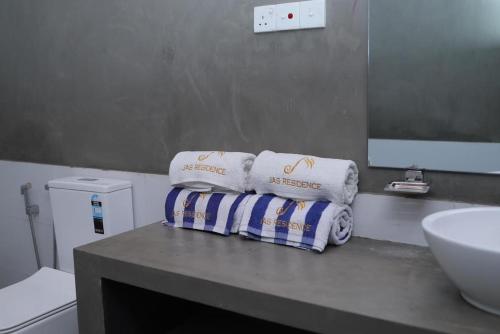 een badkamer met een wastafel en handdoeken op een aanrecht bij J Villa in Gampaha
