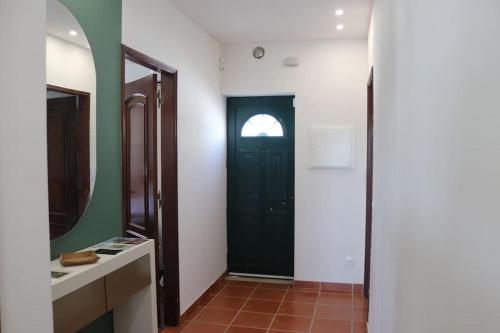 a bathroom with a black door and a mirror at Alieira's House - Pet Friendly in Torres Novas